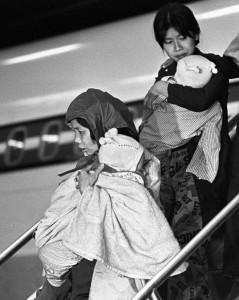 Two women getting off a plane carrying their young child